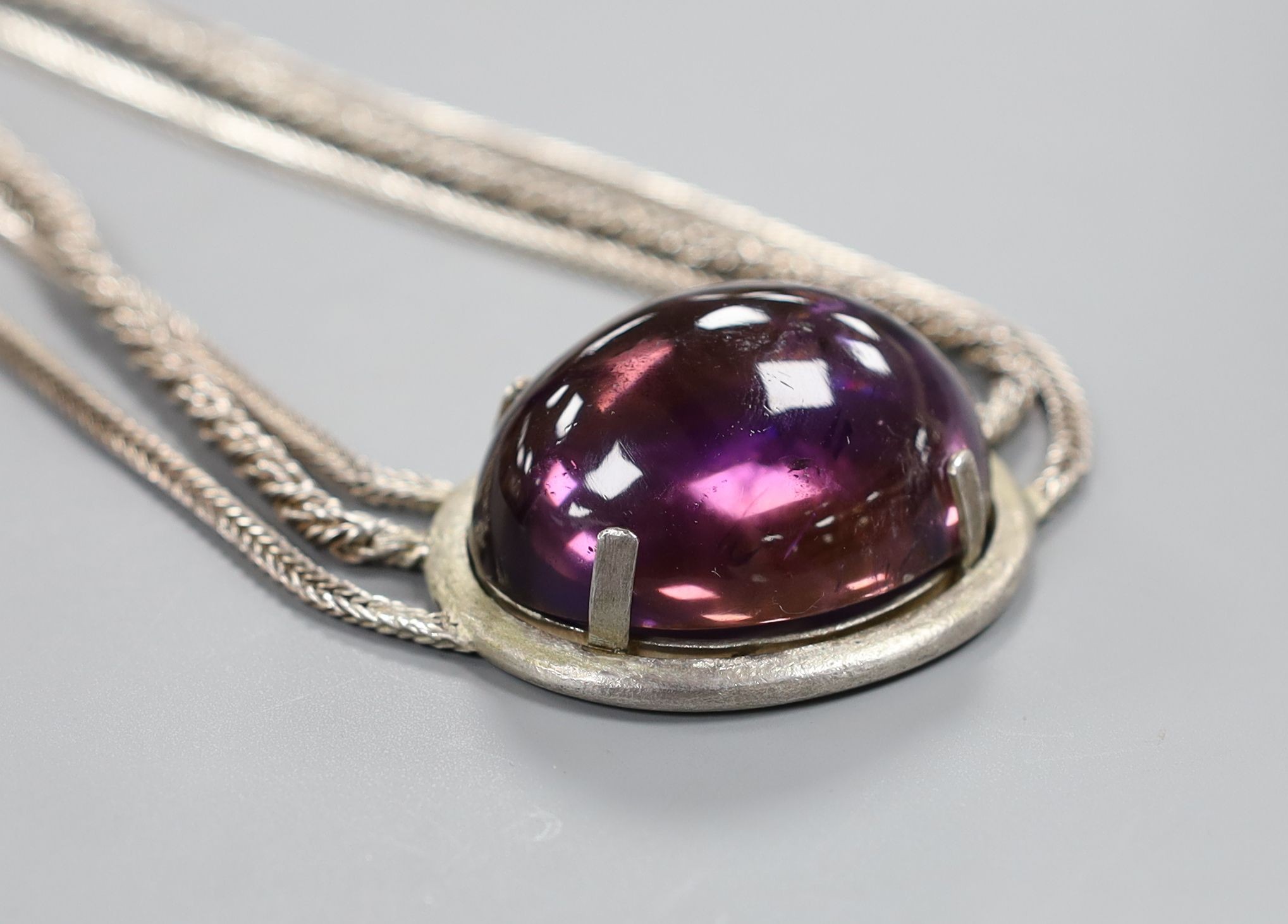 A white metal and large cabochon oval amethyst set triple strand necklace, 47cm